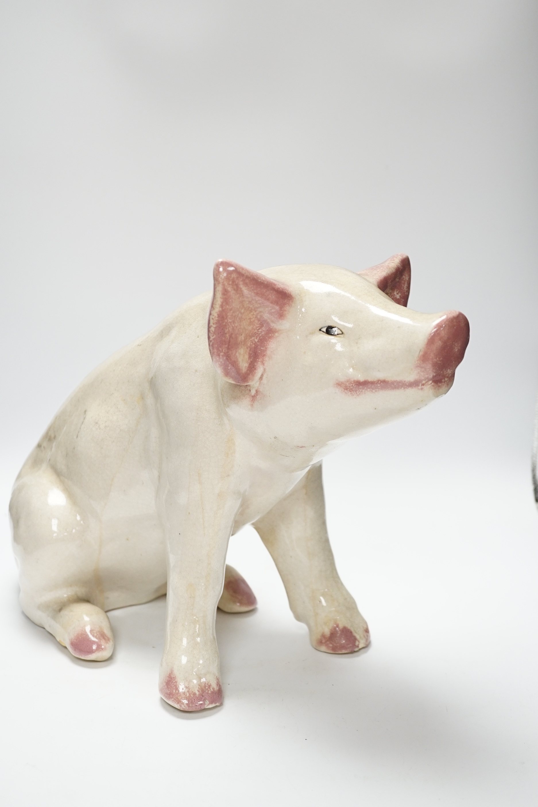 A large earthenware model of a seated piglet, 31cm high